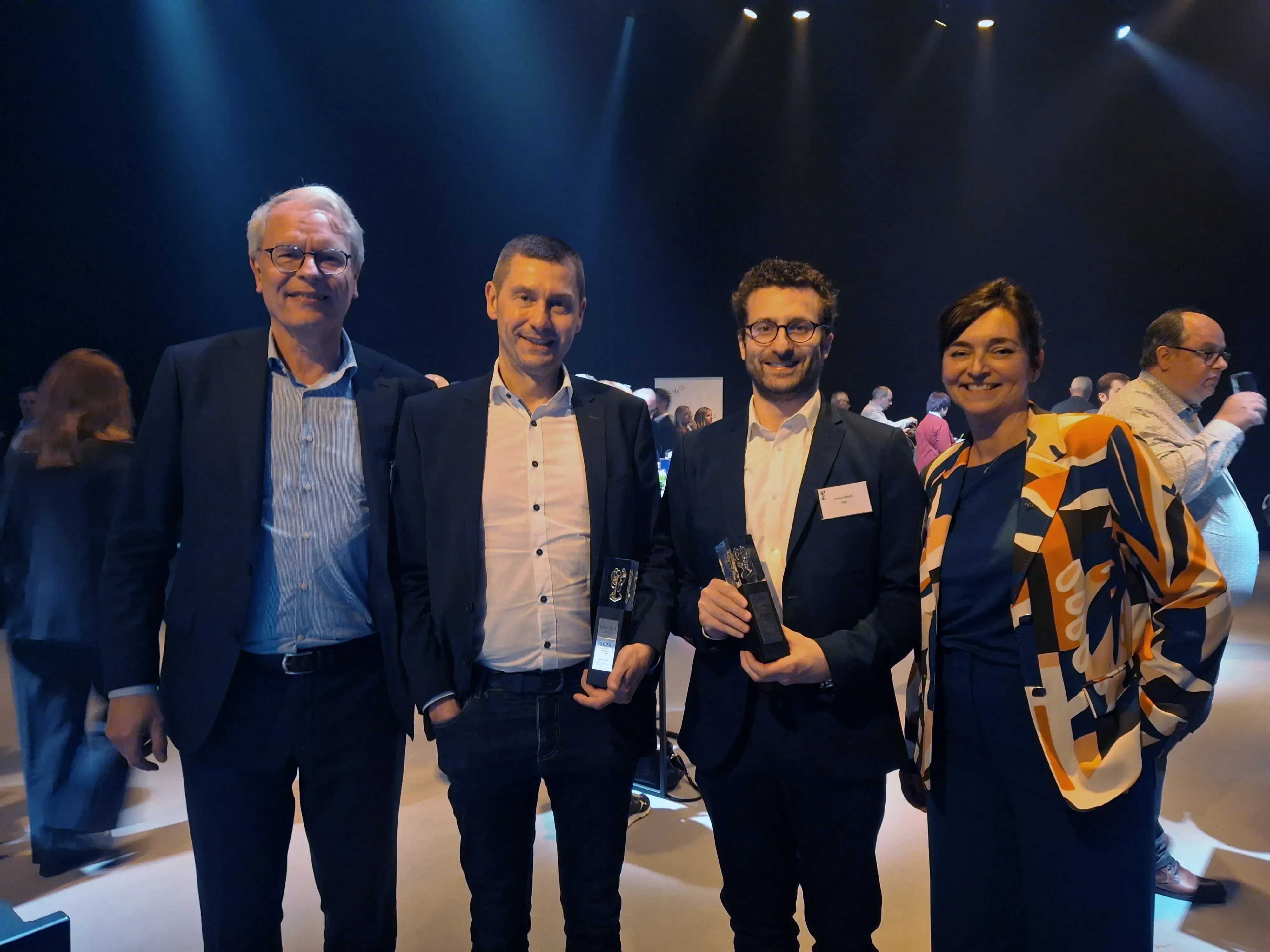 Vier collega's van P&V Groep poseren met een Decavi-trofee